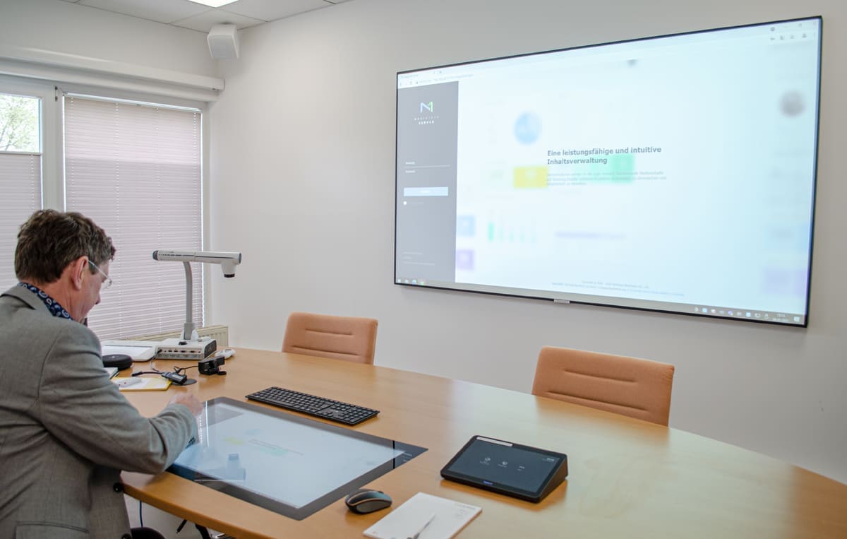 Präsentation auf eine Beamer-Leinwand mit PC, Vorschaumonitor im Tisch und Dokumentenkamera