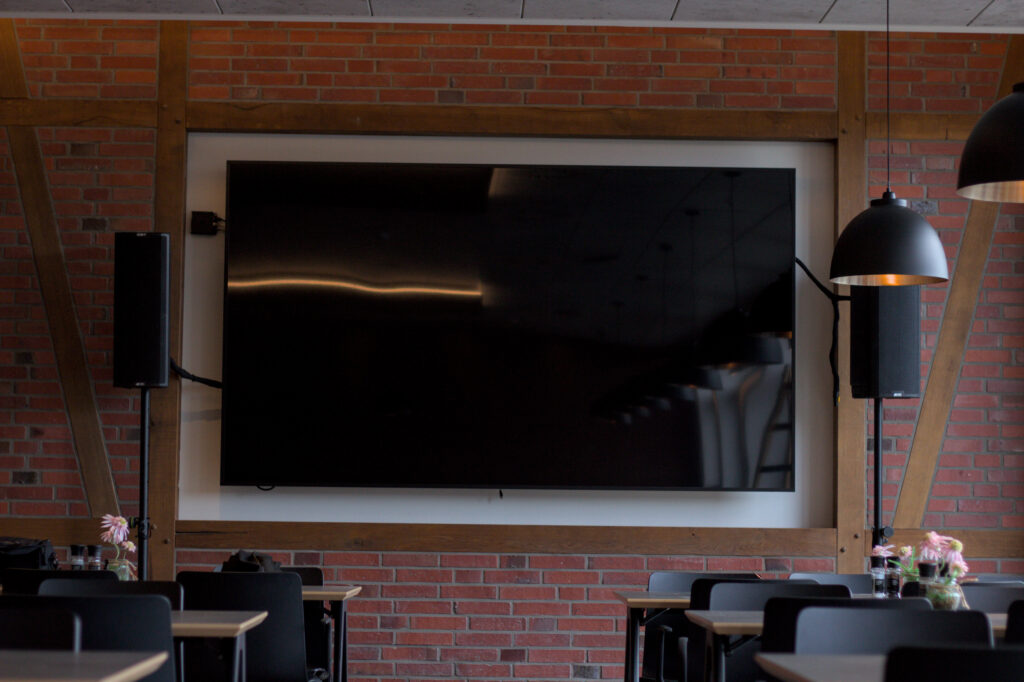 Eine Wand mit zwei stehenden Lautsprechern und einem großen Display