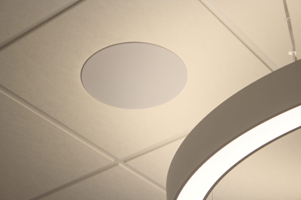 Eingelassener, weißer Deckenlautsprecher in weißen Deckenkacheln