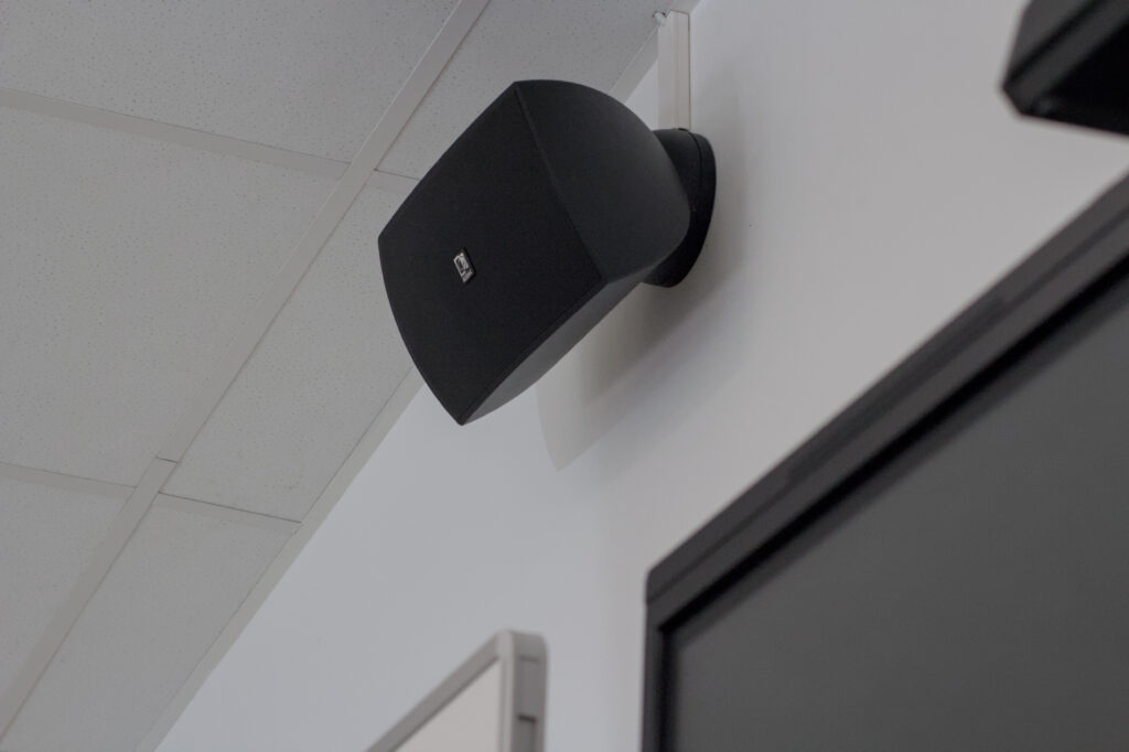 Schwarzer Lautsprecher an einer weißen Wand