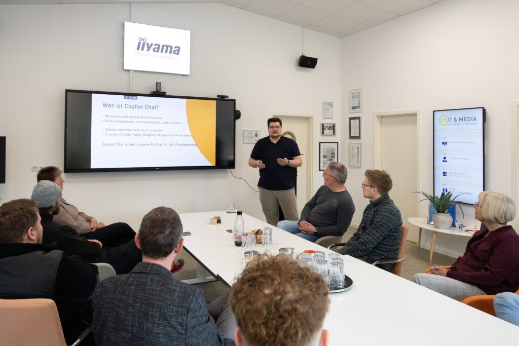 Ein Mitarbeiter stellt seinen Kollegen im Unternehmen vor, was Microsoft Copilot ist